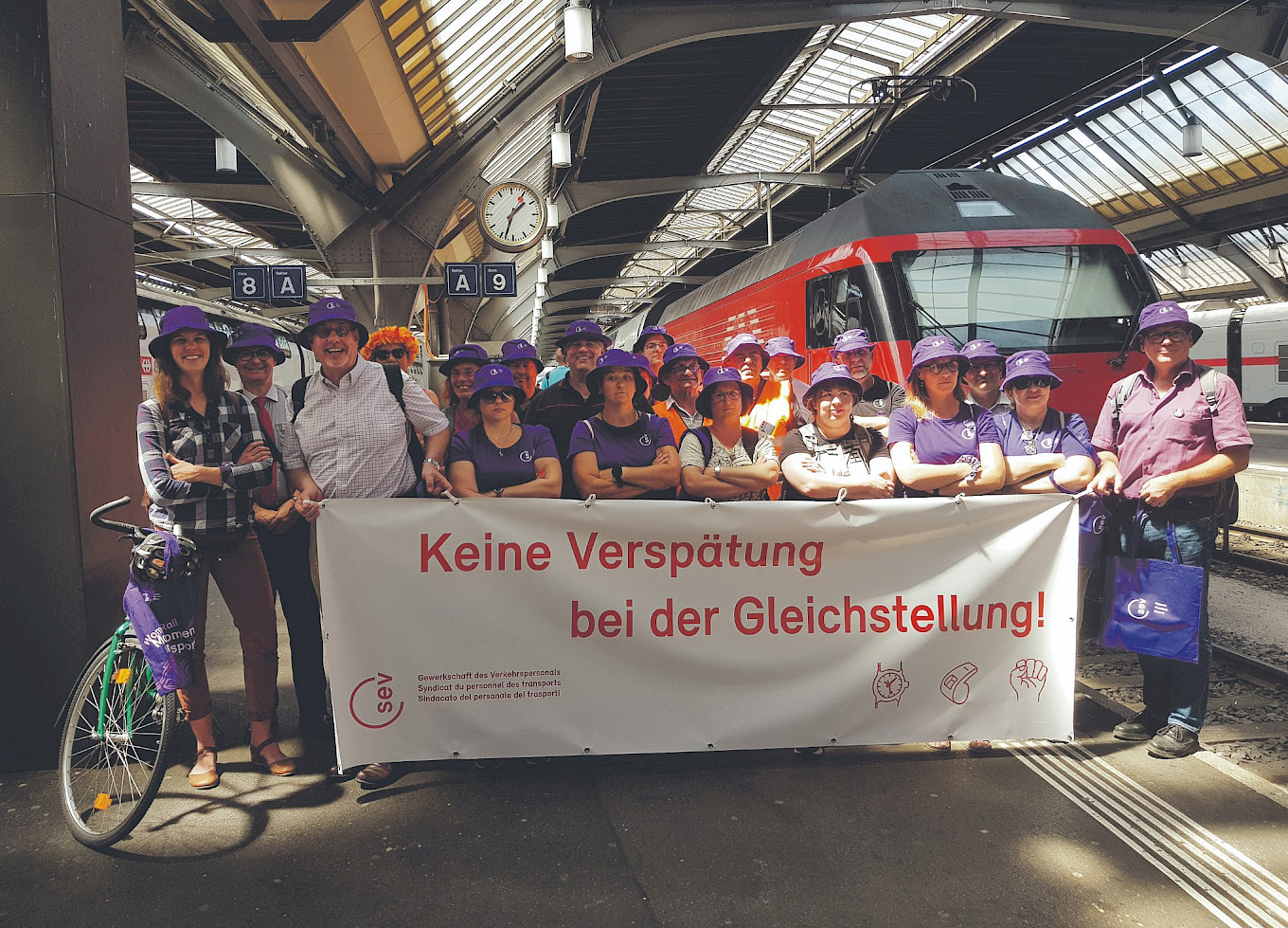 HB Zürich. Illustration des Einkommensunterschieds von 43,2 % zwischen Mann und Frau über die Erwerbszeit (Alter 15 bis 64): Umgerechnet auf einen Acht-Stunden-Arbeitstag (8–12 /13–17) beträgt die Differenz 3 h 27. Das heisst, die Frauen arbeiten ab 13 Uhr 33 gratis!